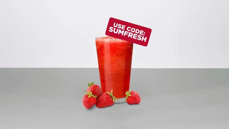 A red frozen blended drink with strawberries